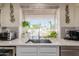 Bright kitchen sink area with marble countertops and view of the landscaped backyard with pool at 5237 N 106Th Ave, Glendale, AZ 85307