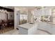 Open-concept kitchen with a center island, stainless steel refrigerator, and white cabinetry at 5237 N 106Th Ave, Glendale, AZ 85307