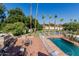 Stunning backyard pool with an outdoor kitchen, fireplace, tiled patio, and lush landscaping, perfect for outdoor entertaining at 5237 N 106Th Ave, Glendale, AZ 85307
