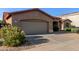 View of the home's front exterior and driveway, showcasing the attached garage and desert landscape at 5314 W Bowker St, Laveen, AZ 85339