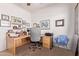 Well-lit home office featuring light wood desk, modern chair and walls adorned with various framed artworks at 5314 W Bowker St, Laveen, AZ 85339