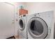 Functional laundry room with modern washer and dryer, storage cabinet, and door to the exterior at 5314 W Bowker St, Laveen, AZ 85339