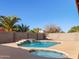 Well-maintained pool and spa with a waterfall feature, surrounded by lush greenery and privacy walls at 5314 W Bowker St, Laveen, AZ 85339