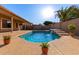 Outdoor swimming pool with a waterfall feature, surrounded by a spacious patio and lush landscaping at 5314 W Bowker St, Laveen, AZ 85339