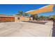Expansive backyard featuring a shaded seating area, wooden garage door and ample paved space perfect for outdoor entertaining at 6329 E Voltaire Ave, Scottsdale, AZ 85254