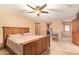 Bedroom with wood trim, tile floors, a ceiling fan, and a connecting bathroom and doorway at 6329 E Voltaire Ave, Scottsdale, AZ 85254