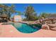 Inground pool with a rock waterfall, fenced in for safety, in a well-maintained backyard at 6329 E Voltaire Ave, Scottsdale, AZ 85254