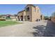 A large backyard with tan stucco house, grass, and storage shed at 6922 S Black Hills Way, Chandler, AZ 85249
