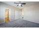 Bedroom with neutral walls, a gray carpet, a ceiling fan, and closet with sliding doors at 6922 S Black Hills Way, Chandler, AZ 85249
