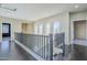 Upstairs hallway with dark hardwood floors, metal railing, and an abundance of natural light at 6922 S Black Hills Way, Chandler, AZ 85249