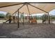 A playground with a large shade canopy, various play structures, and a sand-filled ground at 6922 S Black Hills Way, Chandler, AZ 85249