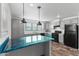 Well-lit kitchen featuring a central island, modern pendant lighting, and stylish appliances at 701 S Dobson Rd # 447, Mesa, AZ 85202