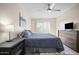 Well-lit bedroom features a bed, dark wood dresser, and ceiling fan at 735 E Cochise Dr, Phoenix, AZ 85020