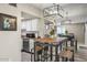 Stylish dining area with high table, seating for four, and contemporary lighting fixtures and view into the kitchen at 735 E Cochise Dr, Phoenix, AZ 85020