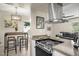 Modern kitchen with stainless steel range hood, electric stove, and sleek countertop island at 735 E Cochise Dr, Phoenix, AZ 85020