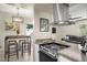 Modern kitchen with stainless steel range hood, electric stove, and sleek countertop island at 735 E Cochise Dr, Phoenix, AZ 85020