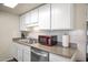 Well-maintained kitchen featuring a stainless steel dishwasher, double sink and a sleek red microwave at 735 E Cochise Dr, Phoenix, AZ 85020