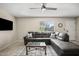 Bright living room featuring a comfortable gray sectional, neutral walls and natural light from the window at 735 E Cochise Dr, Phoenix, AZ 85020