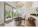 Eat-in dining room with vaulted ceiling, modern chandelier, shutters, and access to patio at 7400 E Gainey Club Dr # 206, Scottsdale, AZ 85258