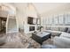 Open concept living room with fireplace, mounted tv, staircase, shutters, and modern fixtures at 7400 E Gainey Club Dr # 206, Scottsdale, AZ 85258