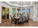 Bright dining room with wood floors, stylish chandelier, and scenic views through large windows at 8229 N Ridgeview Dr, Paradise Valley, AZ 85253