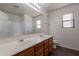 Bathroom with dual sinks, wood cabinets, and tile flooring at 9534 N 82Nd Ln, Peoria, AZ 85345