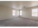 Large bedroom featuring neutral carpet, white walls, and bright windows at 9534 N 82Nd Ln, Peoria, AZ 85345