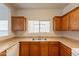 Cozy kitchen featuring wood cabinets, laminate countertops, and stainless steel sink at 9534 N 82Nd Ln, Peoria, AZ 85345