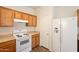 Kitchen features wood cabinets, laminate countertops, white refrigerator, and white oven range at 9534 N 82Nd Ln, Peoria, AZ 85345