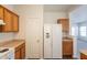 Kitchen features wood cabinets, laminate countertops, white refrigerator, and white appliances at 9534 N 82Nd Ln, Peoria, AZ 85345