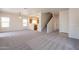 Expansive, carpeted living area showcasing an open floor plan and staircase at 9534 N 82Nd Ln, Peoria, AZ 85345