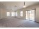 Spacious carpeted living room with bright, natural light and a sliding glass door at 9534 N 82Nd Ln, Peoria, AZ 85345