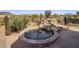 Backyard oasis featuring desert landscaping, a tranquil water feature, and mature cacti at 9802 E Hidden Valley Rd, Scottsdale, AZ 85262