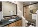 Neutral bathroom with a vanity and dark countertops, enclosed shower, and custom wall accents at 9802 E Hidden Valley Rd, Scottsdale, AZ 85262