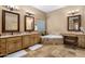 Luxury bathroom with dual vanities, a soaking tub, and tile flooring at 9802 E Hidden Valley Rd, Scottsdale, AZ 85262
