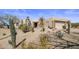 Beautiful home exterior with desert landscaping, native cacti, and a private gated entrance at 9802 E Hidden Valley Rd, Scottsdale, AZ 85262
