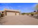 Spacious three-car garage featuring stylish stone accents and ample parking space on a large driveway at 9802 E Hidden Valley Rd, Scottsdale, AZ 85262
