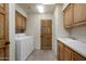 Functional laundry room with washer, dryer, ample storage, and utility sink at 9802 E Hidden Valley Rd, Scottsdale, AZ 85262