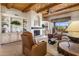 Living room showcasing a fireplace, wood beamed ceilings, and comfortable seating at 9802 E Hidden Valley Rd, Scottsdale, AZ 85262