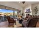 Inviting living room with leather furniture, fireplace, and sliding doors to the outdoor patio at 9802 E Hidden Valley Rd, Scottsdale, AZ 85262