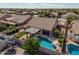 A backyard featuring a swimming pool, a grassy lawn, and a shaded pergola area at 10413 E Emelita Ave, Mesa, AZ 85208