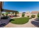 Inviting backyard with a well-manicured lawn, gravel landscaping, and a cozy covered patio area perfect for relaxing at 10413 E Emelita Ave, Mesa, AZ 85208