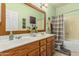 Green bathroom featuring a double vanity, large mirror, and a shower/tub combination at 10413 E Emelita Ave, Mesa, AZ 85208