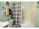 Green bathroom features a shower/tub combination with coordinated towel sets at 10413 E Emelita Ave, Mesa, AZ 85208
