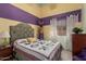 Stylish bedroom with colorful walls, matching bedspread and window at 10413 E Emelita Ave, Mesa, AZ 85208
