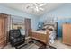 Cozy bedroom with a wooden bed frame, blue walls, and a comfortable sitting area at 10413 E Emelita Ave, Mesa, AZ 85208
