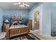 Bedroom features a wooden bed, a neutral carpet and an attached bathroom at 10413 E Emelita Ave, Mesa, AZ 85208
