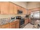 Close-up of kitchen showcasing stainless steel appliances, granite countertops, and ample cabinet space at 10413 E Emelita Ave, Mesa, AZ 85208