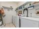 Well-organized laundry room with storage shelves, washer, dryer, and adjacent freezer at 10413 E Emelita Ave, Mesa, AZ 85208
