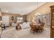 Open-concept living room with dining area featuring neutral tones, plush seating, and stylish chandelier at 10413 E Emelita Ave, Mesa, AZ 85208